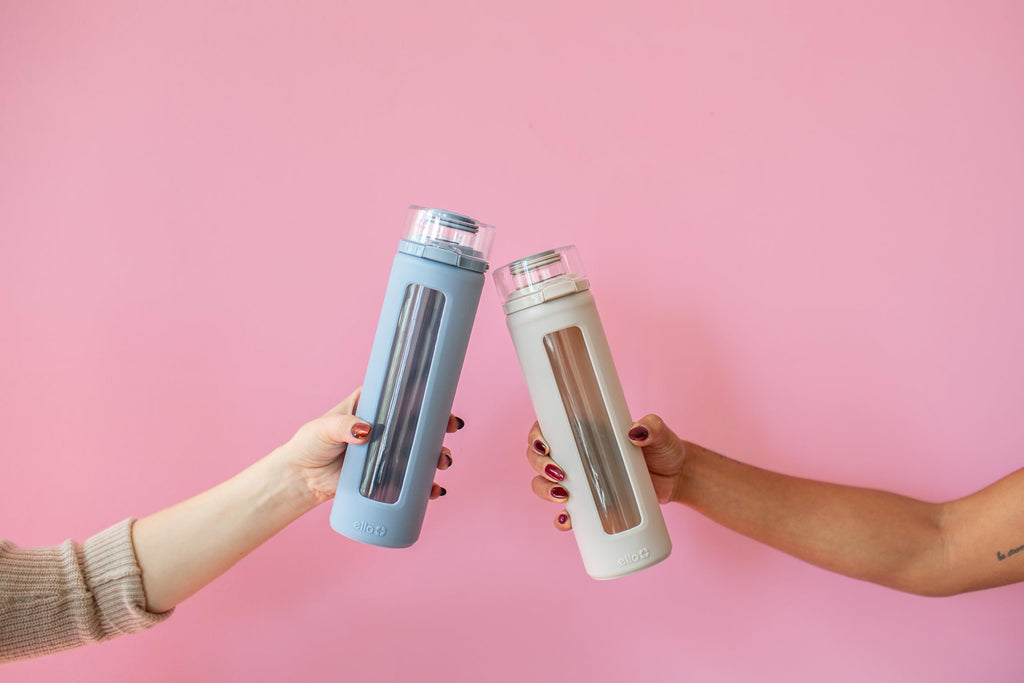 Ello Syndicate 20oz Reusable Glass Water Bottle with One-Touch Leak Proof Flip Lid, Protective Non-Slip Silicone Sleeve, Carry Loop for Coffee, Tea and Water, BPA-free, Dishwasher Safe, Sand